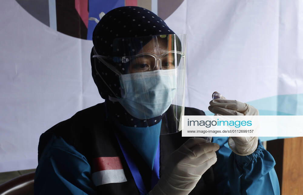 Indonesia s COVID-19 Mass Vaccination A health worker prepares vaccinates her colleague during COVID-19 mass vaccination for medical workers and elderly health workers in Bogor, West Java on February 11, 2021. (Photo by Adrian INA Photo Agency)