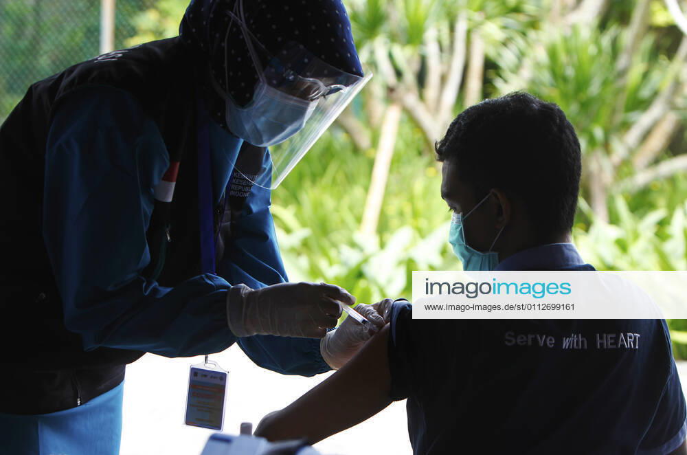 Indonesia s COVID-19 Mass Vaccination A health worker vaccinates her colleague during COVID-19 mass vaccination for medical workers and elderly health workers in Bogor, West Java on February 11, 2021. (Photo by Adrian INA Photo Agency)