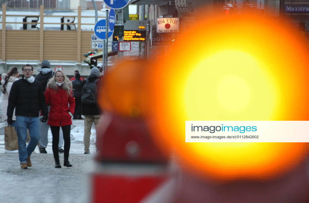 Orange Ampel , People walk with Safety Mask FFP2 during the Hard Lockdown of the Covid 19 Coronavirus Pandemie in Furth , Bayern , Deutschland . February 12, 2021.