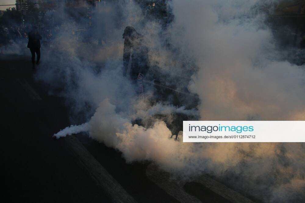 A protester walks between a tear gas bomb thrown by the Police during a demonstration in Plaza Italia in Santiago, Chile, 12 February 2021. The Chilean capital this Friday experienced a new day of protests against the government of President Sebastian Pinera and in rejection of police abuse after the death of juggler Francisco Martinez, shot dead by the Carabineros (militarized police) in a routine identity check. The death of the artist rekindled criticism of the Carabineros and demands to refound the police force. Santiago de Chile lives a new day of protests against the Government and the Carabineros !ACHTUNG: NUR REDAKTIONELLE NUTZUNG!