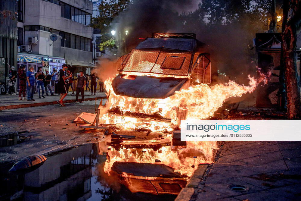 Protester watch as a police vehicle burns down during a protest against police brutality in Santiago..Several protesters took to the streets in a protest that saw a police vehicle being burnt down following the death of a street artist who was shot by police in the city of Panguipulli after he refused to co-operate with a police search. Santiago Chile - ZUMAs197 20210212_zaa_s197_241