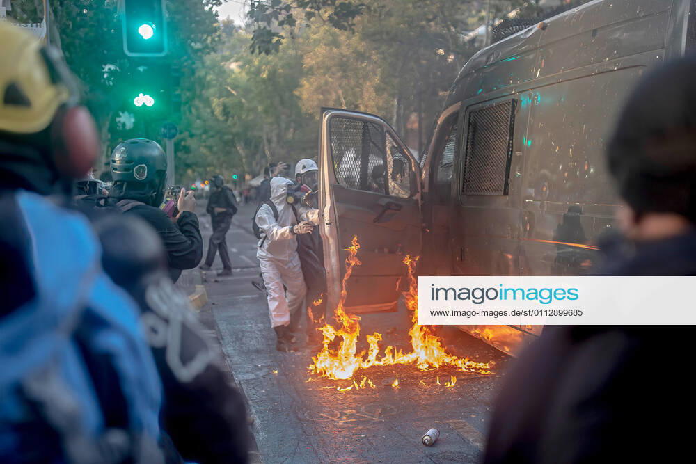 Protesters set a police vehicle on fire as others look on during protests against police brutality in Santiago..Several protesters took to the streets in a protest against President Sebastian Pinera s government, attacking and burning a police vehicle hence injuring an officer following the death of a street artist who was shot by police in the city of Panguipulli after he refused to co-operate with a police search. Santiago Chile - ZUMAs197 20210212_zaa_s197_271