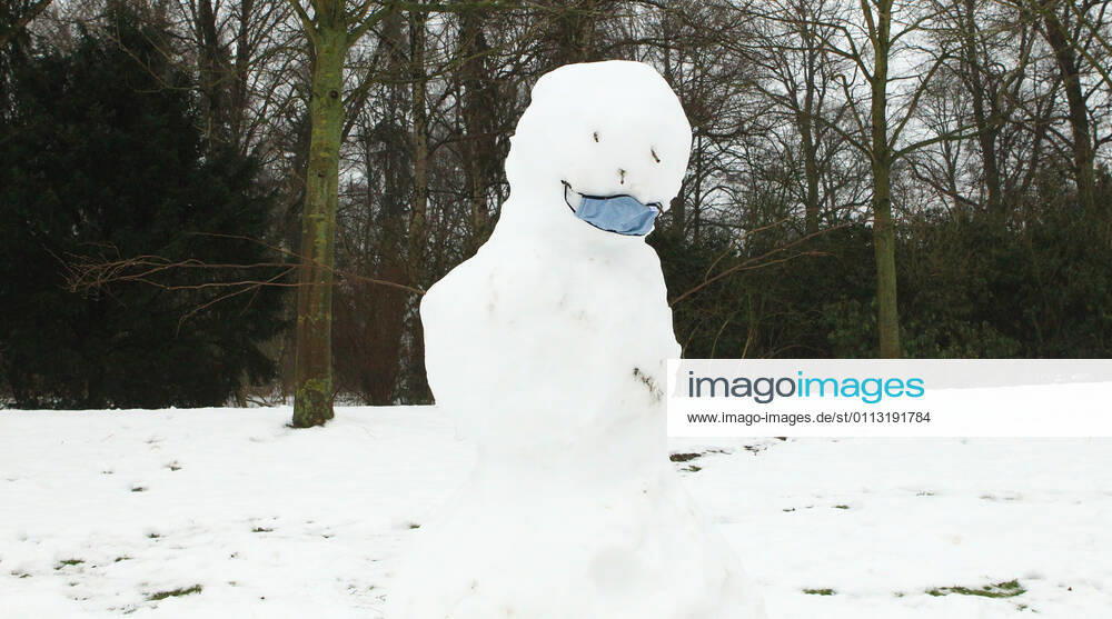 A snowman with a mask stands in the Hamburg city park Winterhude Hamburg