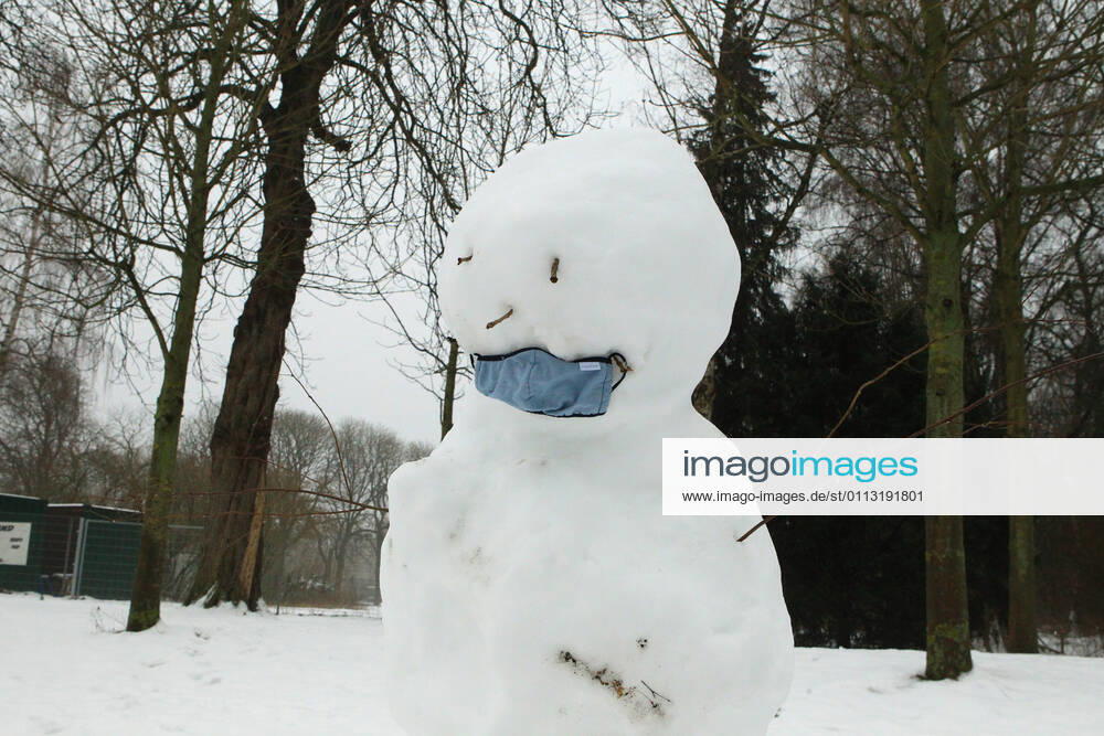 A snowman with a mask stands in the Hamburg city park Winterhude Hamburg