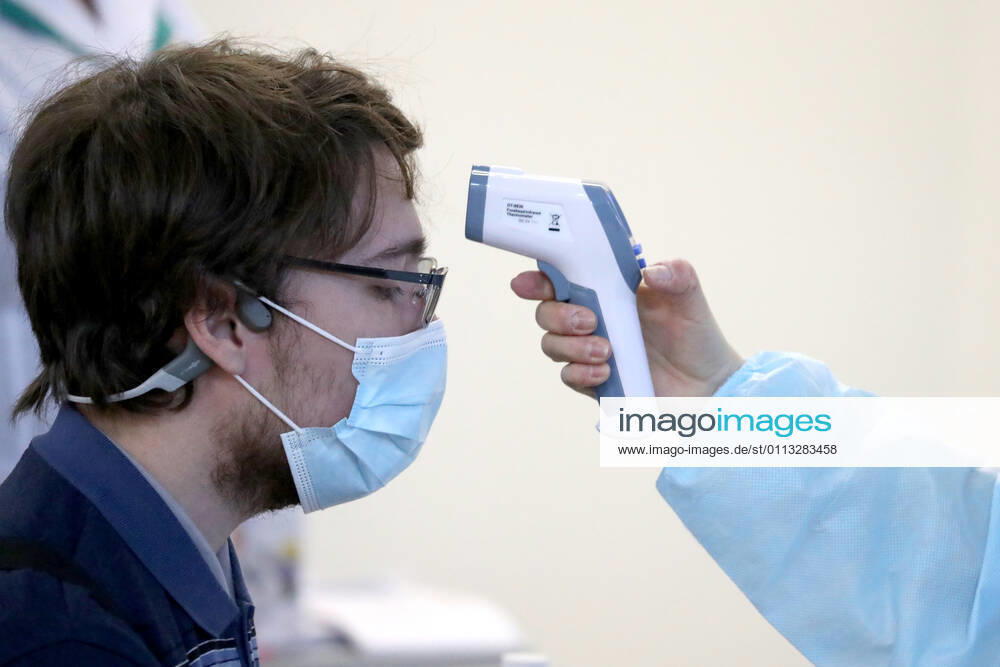 A woman has her temperature measured in a mobile COVID-19 vaccination unit set up at the Dirizhabl Airship shopping centre, injections of the Gam-COVID-Vac (Sputnik-V) free of charge, no prior appointment required. Donat Sorokin TASS TS0F701C