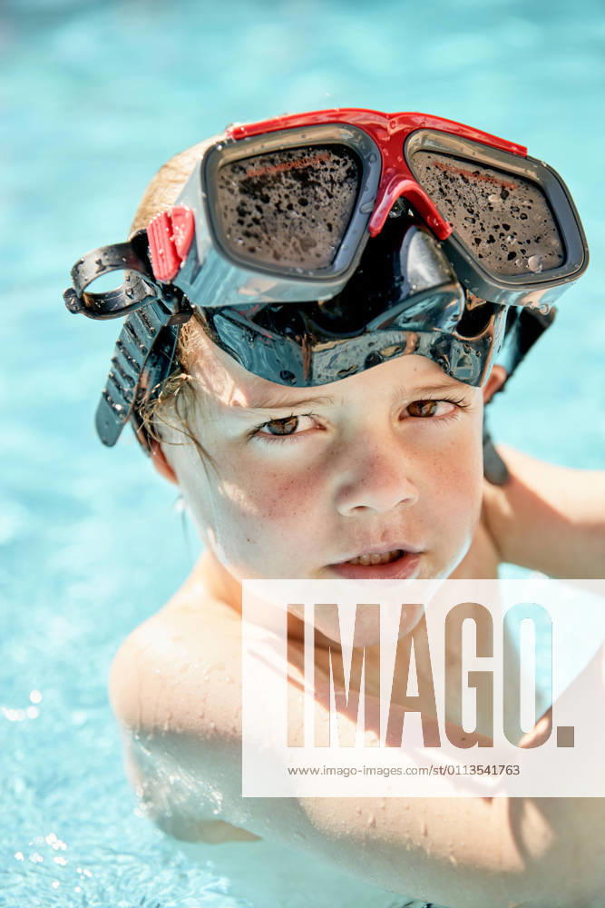 IMAGO Creative: 2021 Favoriten Adorable little boy in snorkeling goggles swimming in outdoor pool before diving training on sunny day