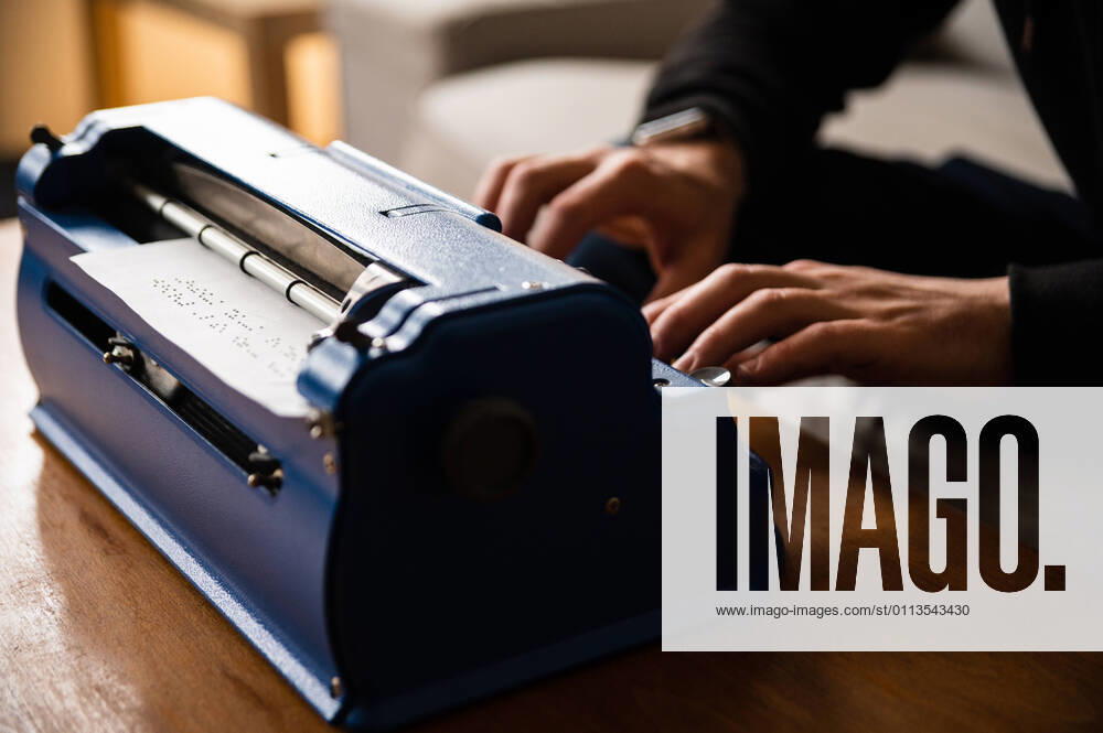 IMAGO Creative: Digitale Welt, Verzicht auf Technologie Crop anonymous visually impaired male typing on typewriter with tactile writing system at home