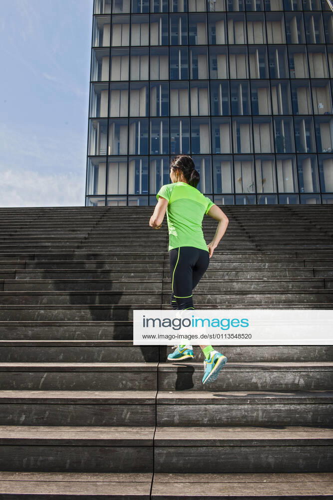 Woman running up wooden stairs in Paris France, Île-de-France, Paris CR_THHE210219-656445-01 ,model released, Symbolfoto
