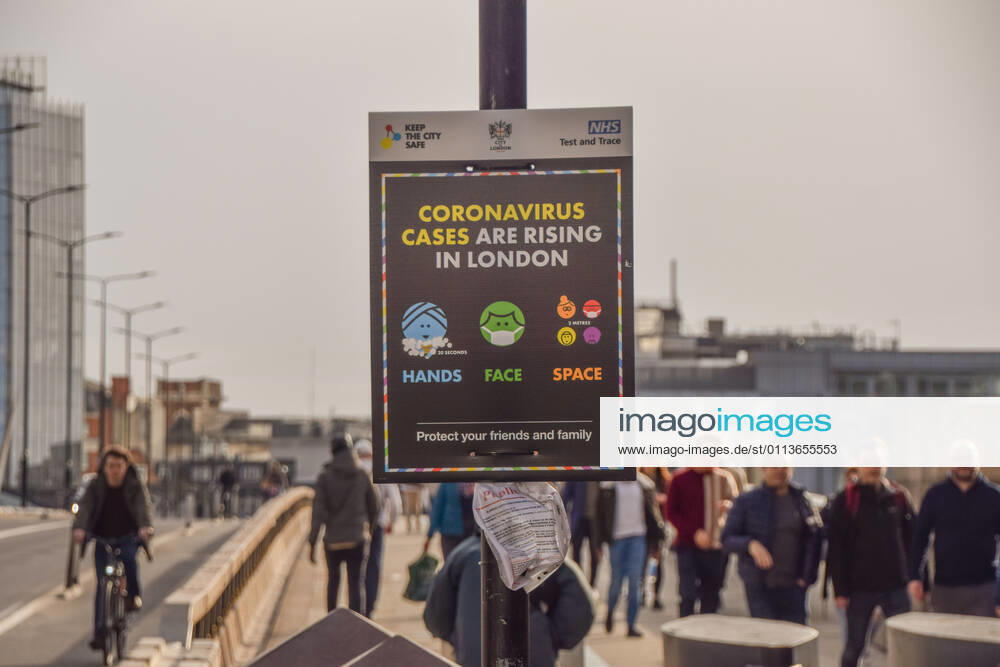 People walk past the Coronavirus Cases Are Rising In London sign on London Bridge..Most businesses remain closed in the capital, as the government plans to ease the lockdown restrictions in the coming weeks. London United Kingdom - ZUMAs197 20210220_zab_s197_004