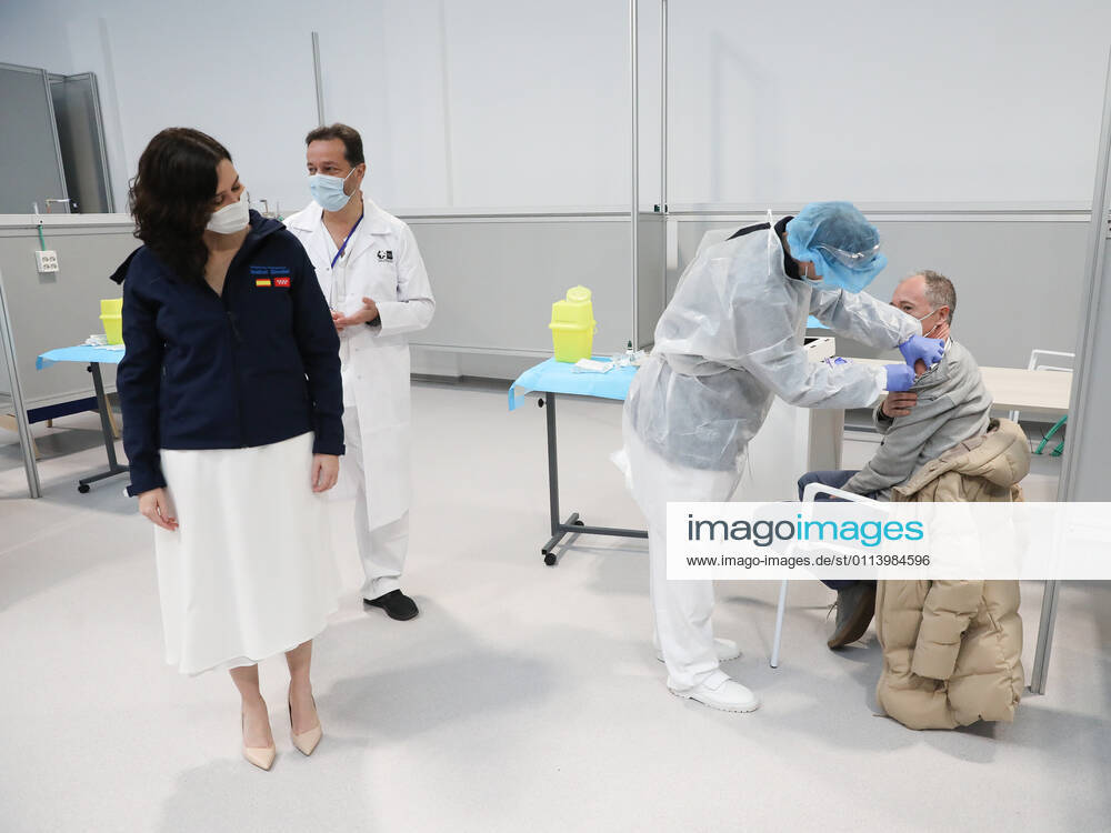 The President of the Community of Madrid, Isabel Diaz Ayuso, watches a man receive the vaccine against COVID-19 during her visit to the start of the vaccination process that has been launched in Pavilion 3 of the Public Hospital Enfermera Isabel Zendal, in Madrid, (Spain), on 23 February 2021. This Tuesday begins the vaccination in the pavilion 3 of the hospital with the vaccine of AstraZeneca to 400 people of external Health, AENA, inspectors of Public Health, of Institute of Social Security, professionals of reformatories, Forensic Doctors, Students of CC Health and veterinarians. These new groups to be vaccinated will be joined by those over 80 years of age on Thursday 25 February in the Primary Care centres of each of the health areas
