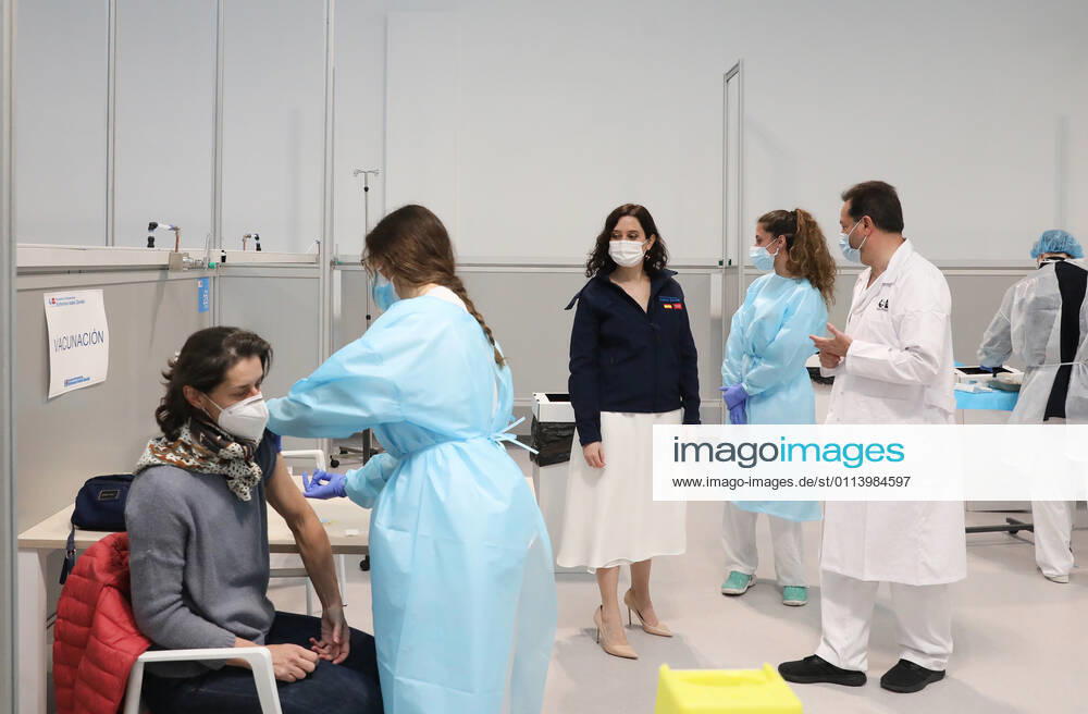 The President of the Community of Madrid, Isabel Diaz Ayuso, watches as a woman receives the vaccine against COVID-19 during her visit to the start of the vaccination process that has been launched in Pavilion 3 of the Public Hospital Enfermera Isabel Zendal, in Madrid, (Spain), on 23 February 2021. This Tuesday begins the vaccination in the pavilion 3 of the hospital with the vaccine of AstraZeneca to 400 people of external Health, AENA, inspectors of Public Health, of Institute of Social Security, professionals of reformatories, Forensic Doctors, Students of CC Health and veterinarians. These new groups to be vaccinated will be joined by those over 80 years of age on Thursday 25 February in the Primary Care centres of each of the health