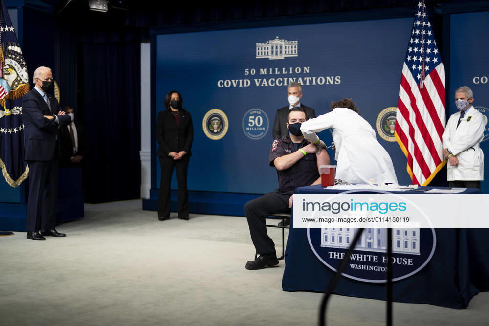 President Joe Biden looks on as a nurse gives a vaccine to Corey Hamilton, a firefighter EMT stationed at Engine Company 9 in Northwest DC, as he participates in an event commemorating the 50 million COVID-19 vaccine shot during a ceremony at the White House, Thursday, Feb. 25, 2021 Washington USA - ZUMAs152 20210225_zaa_s152_193