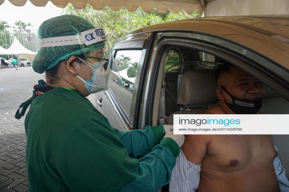 A healthworker inject a dose of Sinovac Biotech vaccine at drive-thru facilities. Bali to held the second stage of Covid-19 mass vaccination towards tourism workers and online-taxi drivers at Bali Nusa Dua Convention Center (BNDCC), in order to accelerate tourism industry recovery. About 5000 doses of vaccines are targeted to be completed within 1 week. Badung Indonesia - ZUMAb245 20210228_zip_b245_003