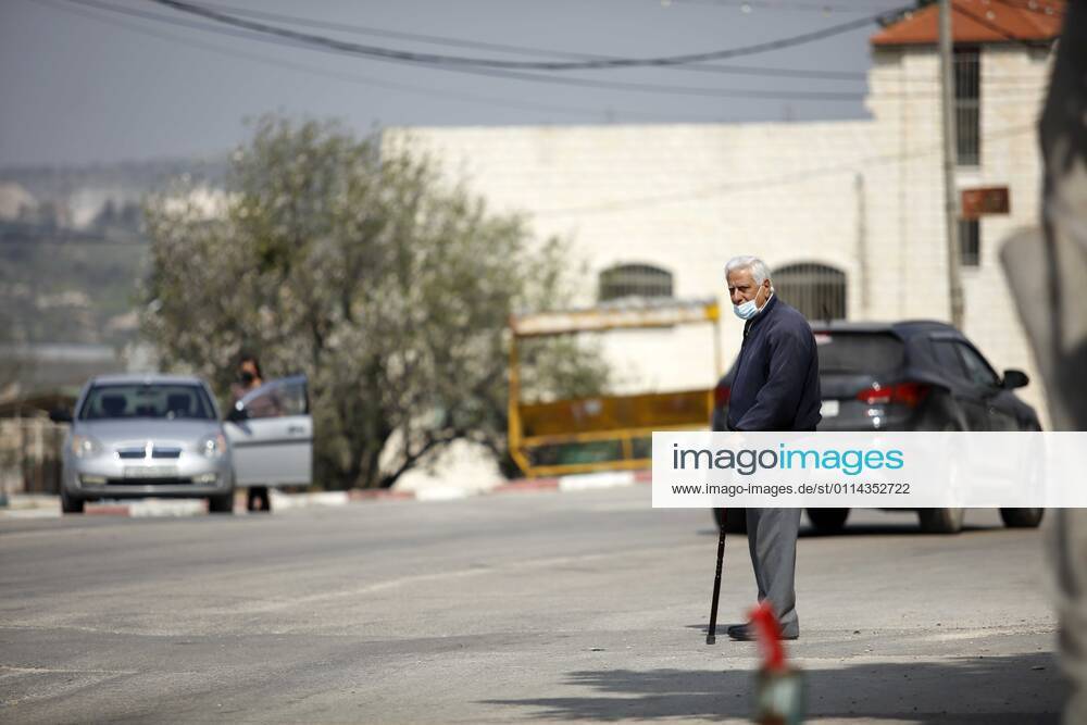 Jenin, West Bank, Palestinian Territory: A man walks on an empty street, amid the coronavirus lockdown in the town of Zababdeh, south of Jenin, in the West Bank on February 28, 2021. Prime Minister Mohammad Shtayyeh announced a new set of restrictions in response to a recent surge in coronavirus infections, including of British and South African mutants, in Palestine.A lockdown of all public and private schools for all classes, except for high school students for a period of 12 days, including kindergartens..A lockdown of all universities, educational and vocational institutes and shifting to distance e-learning programs. A maximum of 50 percent of administrative staff are allowed access to universities..Movement between - ZUMAap3_ 20210228_zaf_ap3_044