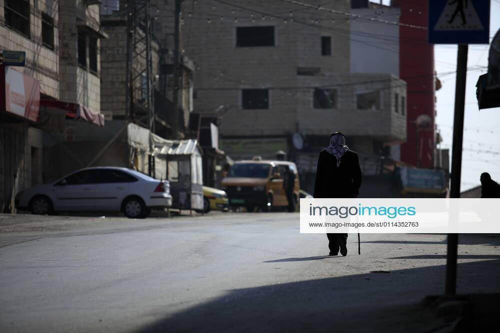 Jenin, West Bank, Palestinian Territory: A man walks on an empty street, amid the coronavirus lockdown in the town of Zababdeh, south of Jenin, in the West Bank on February 28, 2021. Prime Minister Mohammad Shtayyeh announced a new set of restrictions in response to a recent surge in coronavirus infections, including of British and South African mutants, in Palestine.A lockdown of all public and private schools for all classes, except for high school students for a period of 12 days, including kindergartens..A lockdown of all universities, educational and vocational institutes and shifting to distance e-learning programs. A maximum of 50 percent of administrative staff are allowed access to universities..Movement between - ZUMAap3_ 20210228_zaf_ap3_049