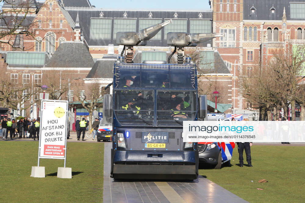 Dutch anti-riot police officers water cannon vehicle team take position near anti-lockdown supporters during illegal demonstration against the coronavirus measures at the Museumplein on February 28, 2021 in Amsterdam,Netherlands. Amsterdam Mayor Femke Halsema classified the Museumplein as security risk area , giving police officers the right to check and search anybody in that area to prevent illegal demonstration and vandalism. Amsterdam Netherlands