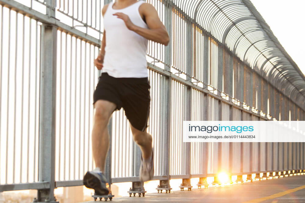 Young man running on bike path in urban city setting Montreal, QC, Canada CR_CHPH210226D-621403-01 ,model released, Symbolfoto
