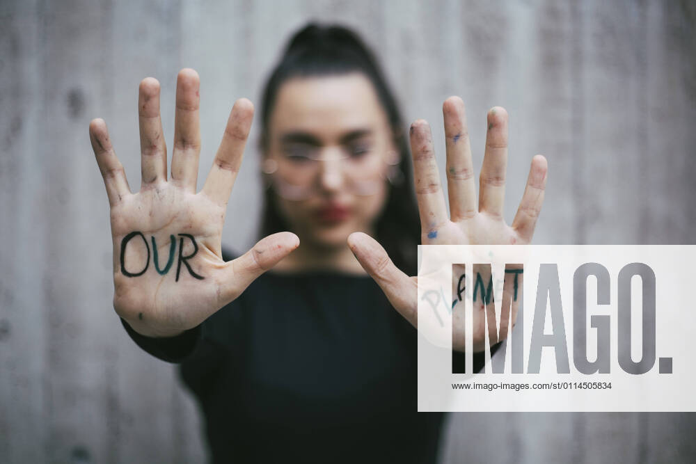 IMAGO Creative: 2022 Aussichten Our planet text written on palms of female activist Sweden, Stockholm, model released
