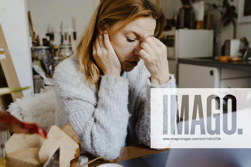 IMAGO Creative: Internationaler Frauenmonat, Gesundheit, Frauen in der Menopause Stressed female entrepreneur working at home Germany, Berlin, model released, property released