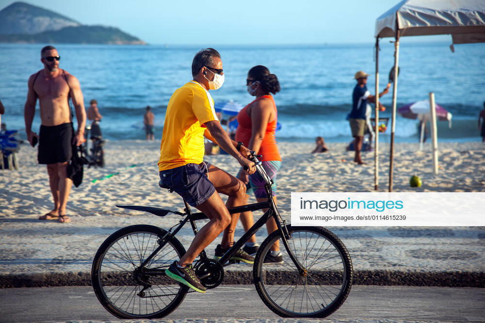 Rio amid COVID-19 RIO DE JANEIRO, RIO DE JANEIRO, BRAZIL, MAR 04: NEW RESTRICTIONS IN TOWN - The city hall has enacted new restrictions to contain the increase in cases of COVID-19 in town. Beach bars, beach food and drink vendors and stalls are prohibited. Man with mask riding a bike at Leblon Beach on March 04, 2021. ( Photo by Chico Ferreira Penta Press ) Rio de Janeiro Brazil 6258_233492
