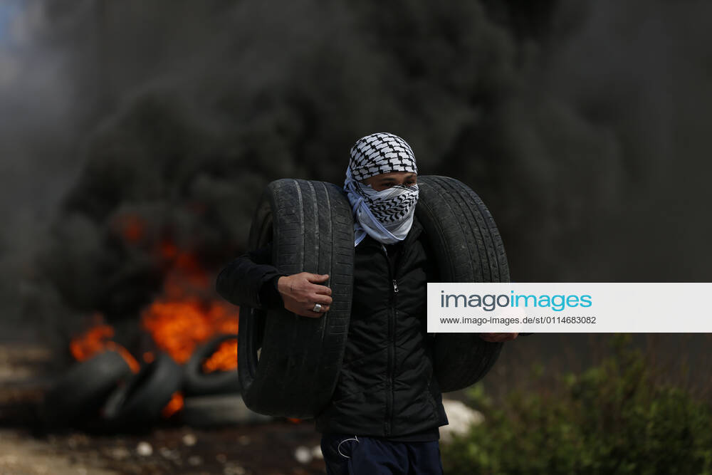 Nablus, West Bank, Palestinian Territory: A Palestinian protester carry tires during clashes with Israel forces following a weekly demonstration against the expropriation of Palestinian land by Israel in the village of Kfar Qaddum, near the West Bank city of Nablus on March 5, 2021. Israel continues to expand existing settlements, as well as annexing more Palestinian land to build new settlements. The cumulative effect has been to deny Palestinians the ability to create a viable state in even a small part of historic Palestine Nablus Palestinian Territory - ZUMAap3_ 20210305_zaf_ap3_008