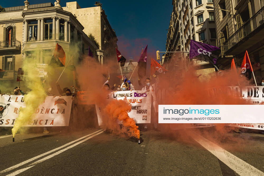 Catalan doctors shout slogans amid colored smoke as they protest for a 100% public health care system, equal pay, labor protection, early retirement, and a reduction of weekly, hours among other demands, during a strike in the Catalan public health care system Barcelona Spain - ZUMAo105 20210310_zap_o105_007