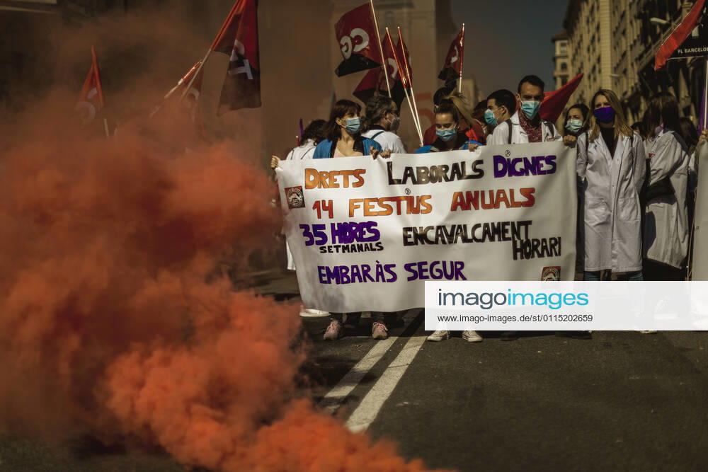 Catalan doctors shout slogans amid colored smoke as they protest for a 100% public health care system, equal pay, labor protection, early retirement, and a reduction of weekly, hours among other demands, during a strike in the Catalan public health care system Barcelona Spain - ZUMAo105 20210310_zap_o105_009