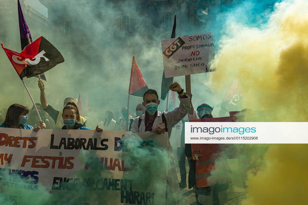 Catalan doctors shout slogans amid colored smoke as they protest for a 100% public health care system, equal pay, labor protection, early retirement, and a reduction of weekly, hours among other demands, during a strike in the Catalan public health care system Barcelona Spain - ZUMAo105 20210310_zap_o105_017