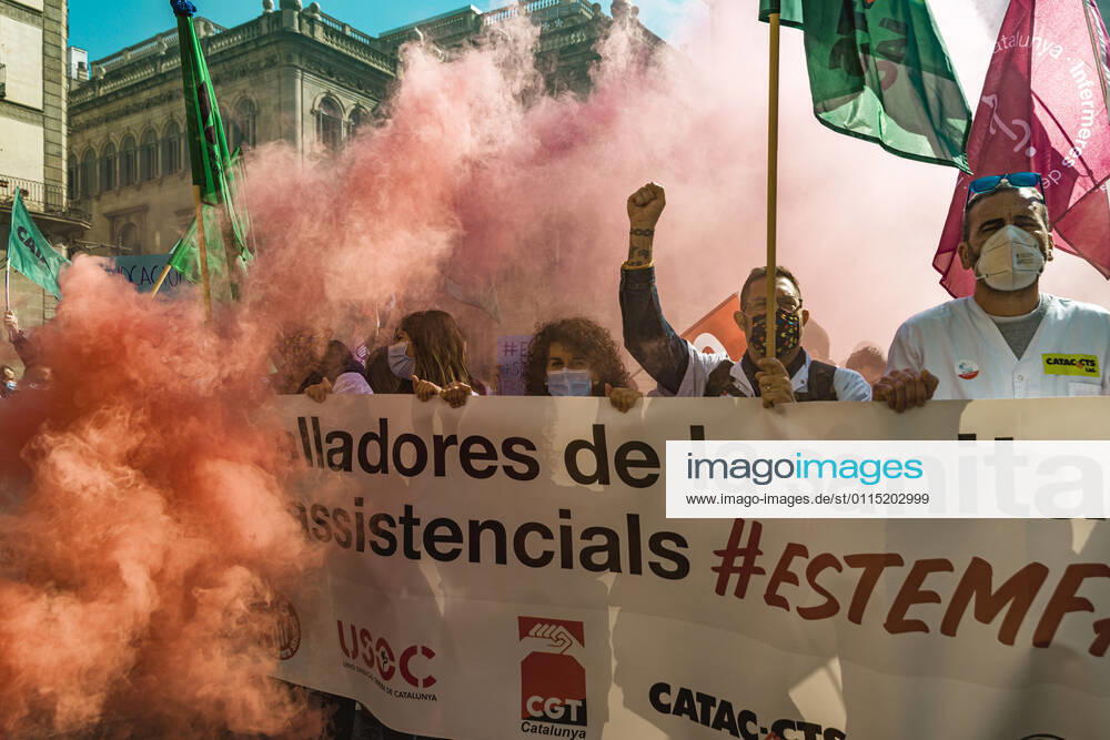 Catalan doctors shout slogans amid colored smoke as they protest for a 100% public health care system, equal pay, labor protection, early retirement, and a reduction of weekly, hours among other demands, during a strike in the Catalan public health care system Barcelona Spain - ZUMAo105 20210310_zap_o105_019