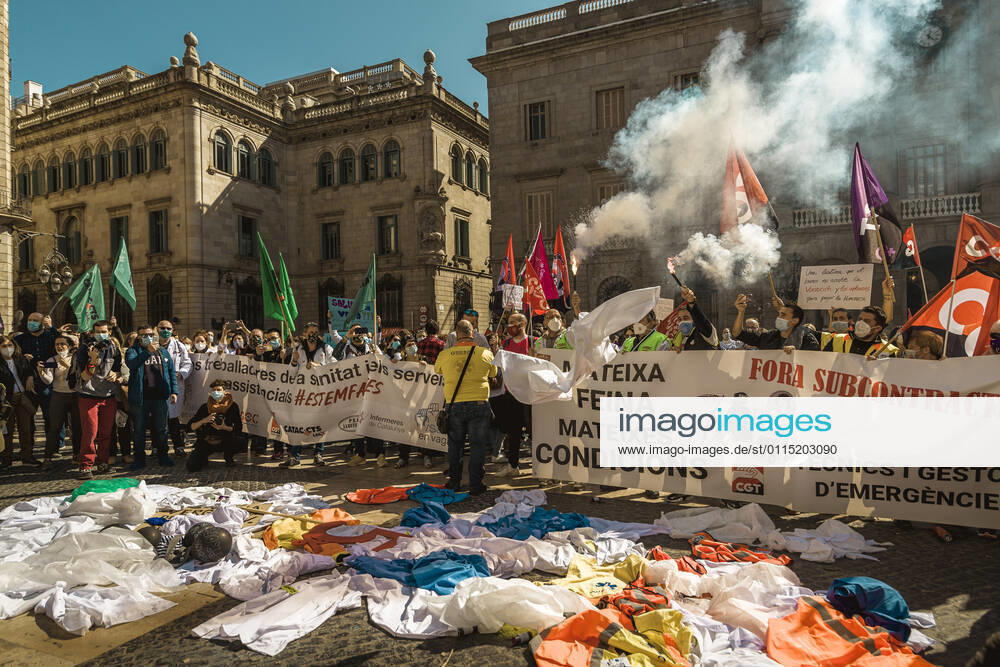 Catalan doctors shout slogans amid colored smoke as they protest for a 100% public health care system, equal pay, labor protection, early retirement, and a reduction of weekly, hours among other demands, during a strike in the Catalan public health care system Barcelona Spain - ZUMAo105 20210310_zap_o105_025