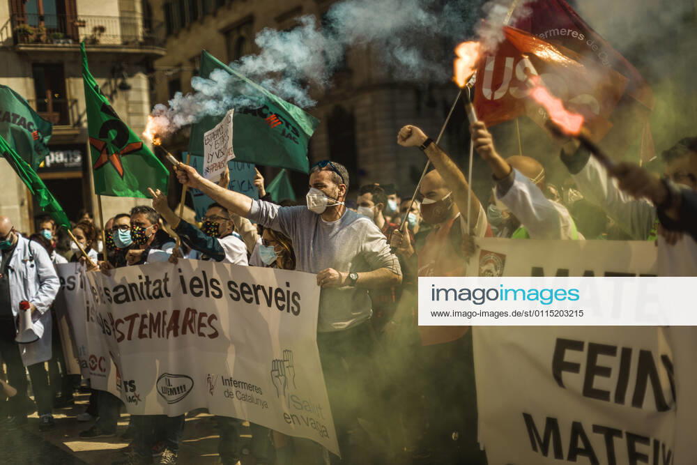 Catalan doctors shout slogans amid colored smoke as they protest for a 100% public health care system, equal pay, labor protection, early retirement, and a reduction of weekly, hours among other demands, during a strike in the Catalan public health care system Barcelona Spain - ZUMAo105 20210310_zap_o105_026