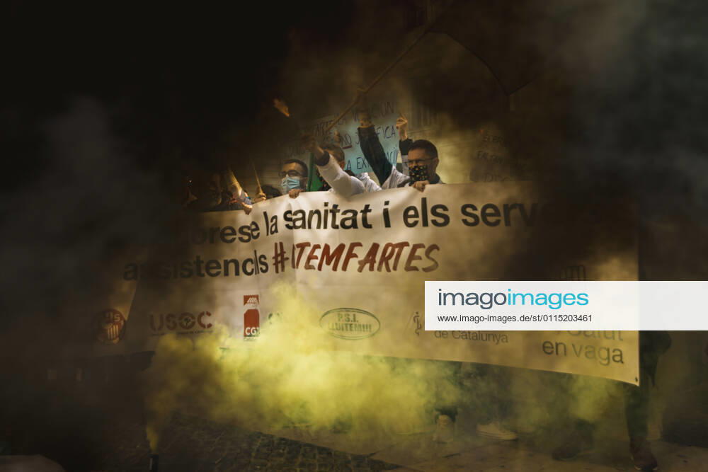 Catalan doctors shout slogans amid colored smoke as they protest for a 100% public health care system, equal pay, labor protection, early retirement, and a reduction of weekly, hours among other demands, during a strike in the Catalan public health care system Barcelona Spain - ZUMAo105 20210310_zap_o105_032