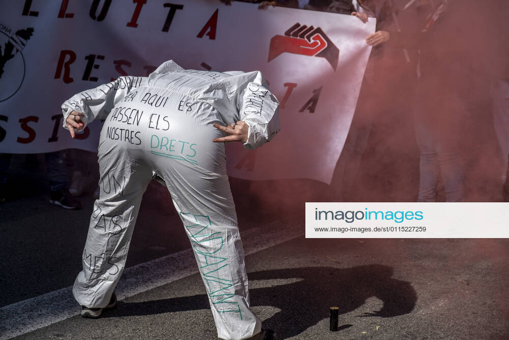 A protester at Via Laietana gestures as she shows the back of her PPE with written messages, during the demonstration..Under the slogan estemfartes (we are fed up), the Catalan Health Union Board, formed by minority unions, has mobilized health workers to a day of strike to denounce the physical fatigue of health professionals and salary cuts. Barcelona Spain - ZUMAs197 20210310_zaa_s197_151