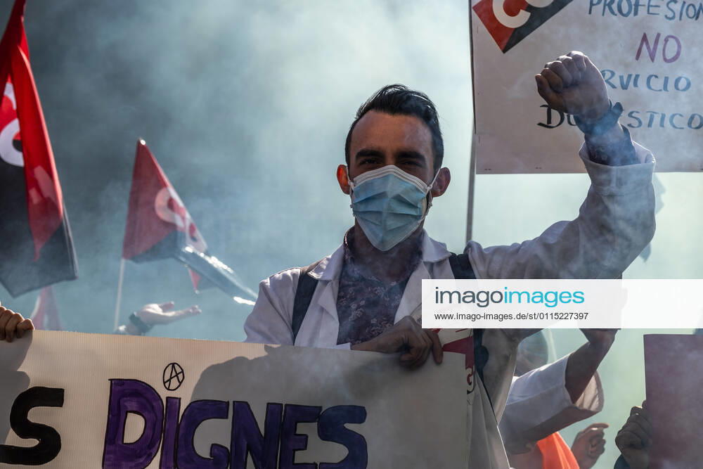A protester at Plaza Sant Jaume raising his fist amid smoke during the demonstration..Under the slogan estemfartes (we are fed up), the Catalan Health Union Board, formed by minority unions, has mobilized health workers to a day of strike to denounce the physical fatigue of health professionals and salary cuts. Barcelona Spain - ZUMAs197 20210310_zaa_s197_157