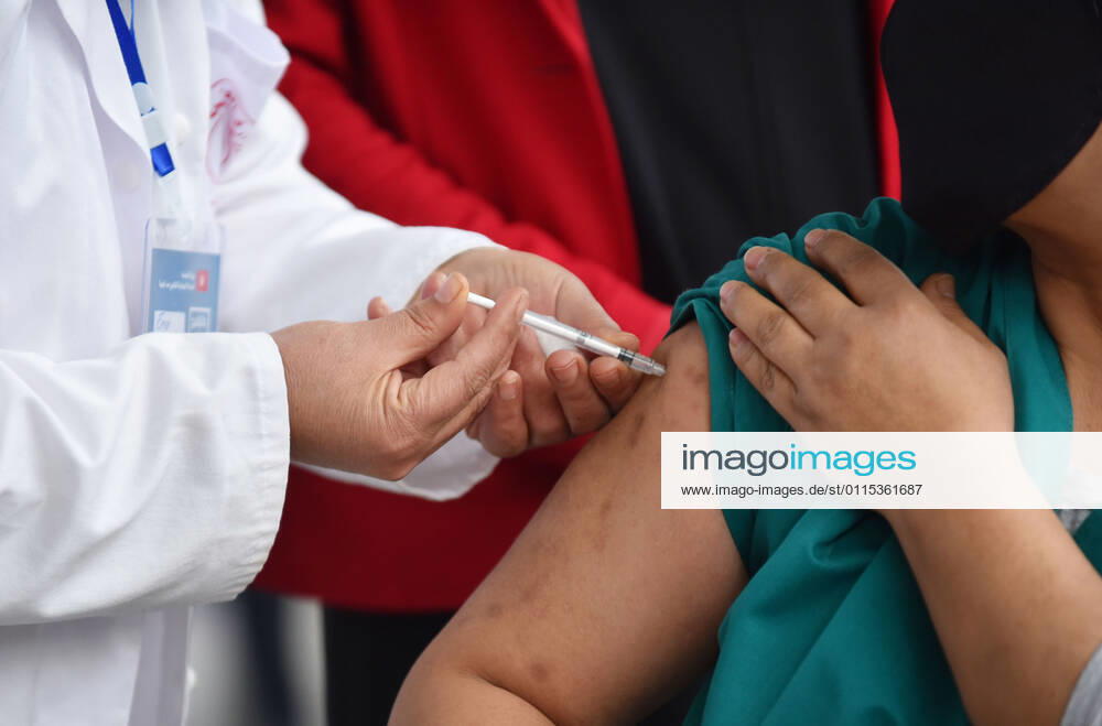 A Tunisian nurse inoculates a health worker against the covid-19..The Tunisian government says that the aim of this session is to reach 50% of the country s population to vaccinate. The vaccine which is currently being distributed to various stations across the country will first be administered to healthcare workers, teachers and people whose immunity is compromised. Tunis Tunisia - ZUMAs197 20210313_zaa_s197_015