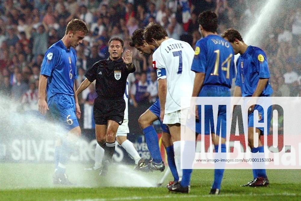 Wasser Marsch ! - Schiedsrichter Luis Medina Cantalejo (Spanien) mahnt zur Vorsicht, de Rossi (li., U21 Italien) und Lazovic (Mitte, U21 Serbien Montenegro) schauen interessiert Fußball EM Herren U 21 Europameisterschaft 2004, Nationalmannschaft, Italien - Serbien und Montenegro 3:0 Gruppe Aufmacher, Sprinkleranlage, Bewässerungsanlage Bochum, Sprinkler, Versenkregner, Bewässerung