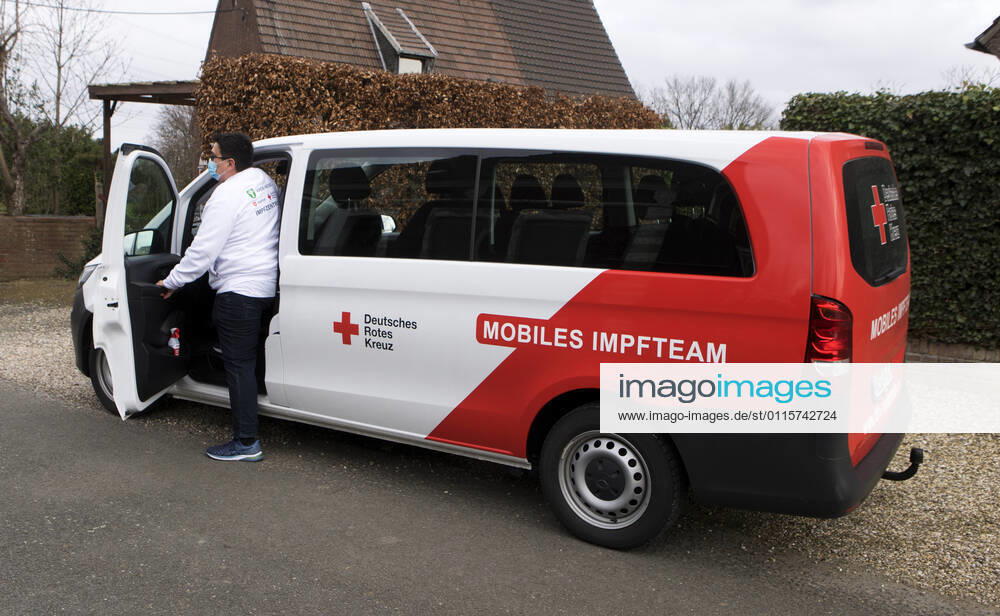 DRK Einsatzfahrzeug Mobiles Impfen Einsatzfahrzeug des DRK Wesel mit der Aufschrift Mobiles Impfteam. Das Fahrzeug wird genutzt zum Transport der Impfdosen zu den Impfzentren oder ambulanten Impforten. Das Fahrzeug steht vor einem Privathaus. Mitarbeiter des DRK Wesel steigt aus dem Einsatzfahrzeug. Moers Deutschland Nordrhein-Westfalen NRW