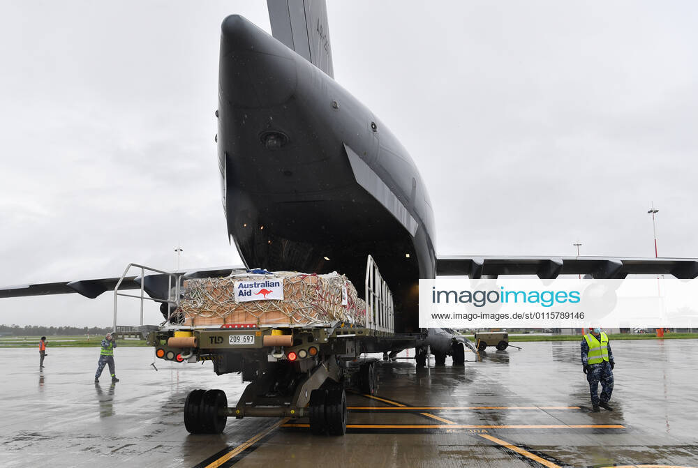 AUSMAT VACCINE PNG COVID19 RESPONSE, Royal Australian Air Force personal are seen loading COVID-19 vaccines and humanitarian supplies onto a C-17A Globemaster at RAAF Base Amberley, west of Brisbane, Tuesday, March 23, 2021. Australia are sending 8,000 doses of its COVID-19 vaccine supply to Papua New Guinea who have more than 1,400 active cases of COVID-19 and the Australian government are asking AstraZeneca and European authorities to divert another 1 million doses to Papua New Guinea. ( NO ARCHIVING, , NO USE IN BOOKS WITHOUT CONSENT BRISBANE QLD AUSTRALIA