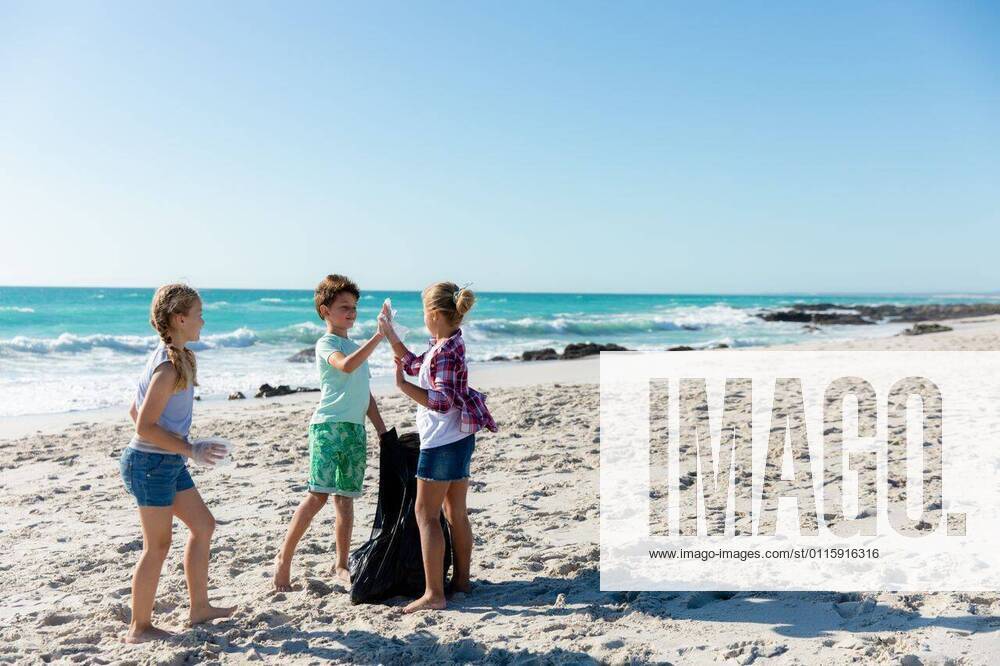 IMAGO Creative: Klimawandel - Umwelterziehung Brother and sisters having fun at the beach Front view of Caucasian siblings on the beach with blue sky and sea in the background, picking up the rubbish and putting it into a trash bag, model released, , property released, Cape Town, South Africa, 21.11.2019, 1310128.jpg, people,real people,enjoy,enjoying,pleasure,lifestyle,free time,holidays,vacation,weekend,activity,relaxing,fun,health,healthy,outdoorsy,fit,leisure,beach,coast,coastal,sea,ocean,sand,sunny,summer,water,blue sky,childhood,brother,sister,siblings,eco-friendly,green,recycling,volunteer,volunteering,environment,cleaning,awareness,social responsibility,community,community spirit,helping,rubbish,collecting,trash,organised,teamwork Young Adult,Woman,Female,Caucasian,Child,Boy,M