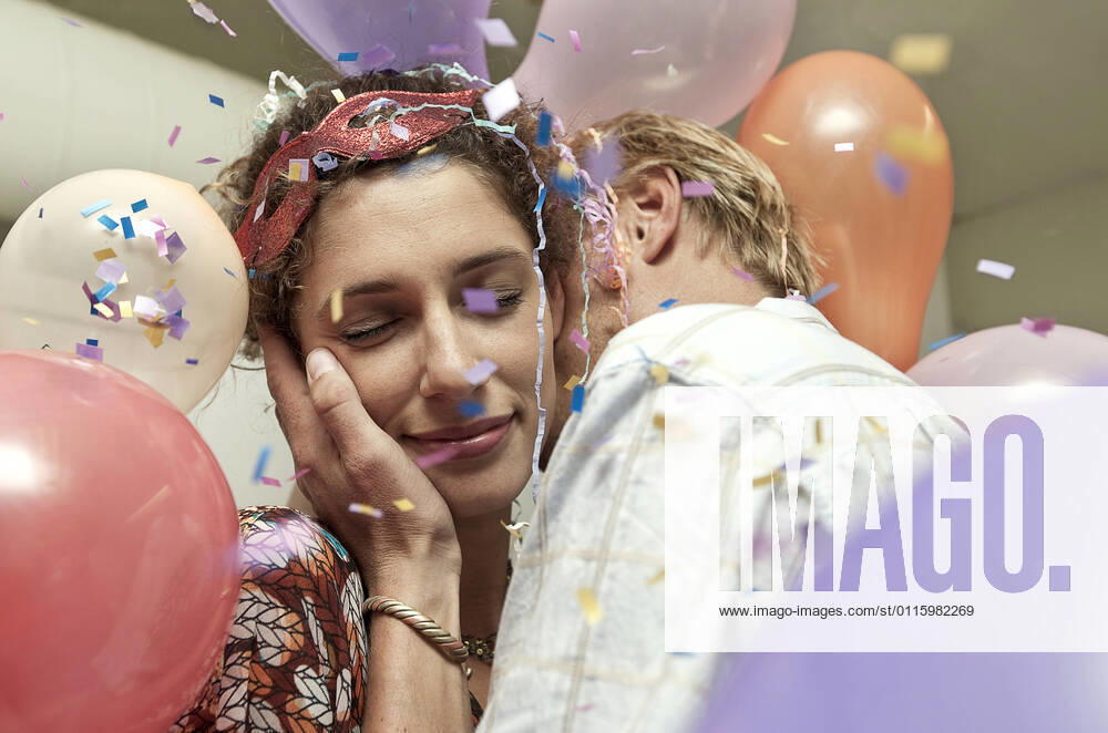IMAGO Creative: 2022 Farbe des Jahres: Very Peri, Veilchenblau Young man and woman kissing at a party model released Symbolfoto AJOF01134