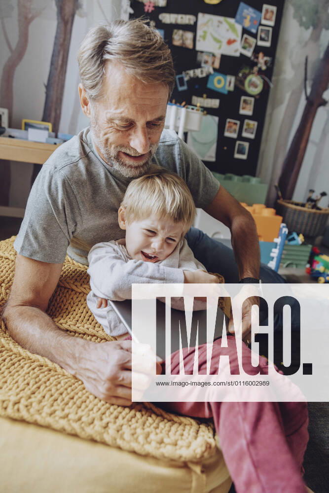 Father struggling while taking digital tablet from displeased son model released Symbolfoto property released MFF07172