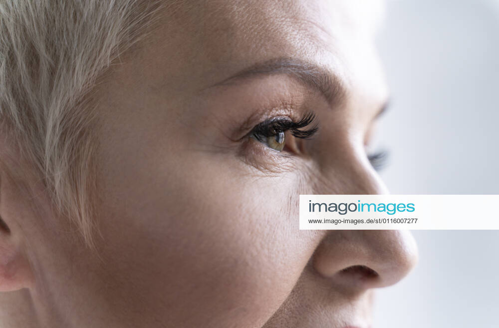 Close-up of senior woman looking away against gray background model released Symbolfoto OIPF00383