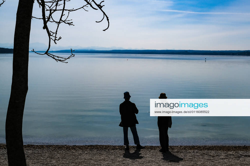Spring weather at the Ammersee 25 03 2021 Excursionist in spring weather at the shore of the Ammersee near Stegen Inning at the Ammersee Upper Bavaria with view towards the Alps Inning Bavaria Germany