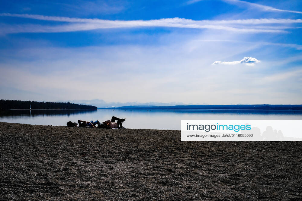 Spring weather at the Ammersee 25 03 2021 Excursionist in spring weather at the shore of the Ammersee near Stegen Inning at the Ammersee Upper Bavaria with view towards the Alps Inning Bavaria Germany