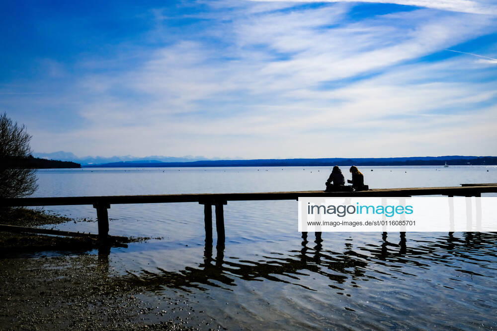 Spring weather at the Ammersee 25 03 2021 Excursionist in spring weather at the shore of the Ammersee near Stegen Inning at the Ammersee Upper Bavaria with view towards the Alps Inning Bavaria Germany