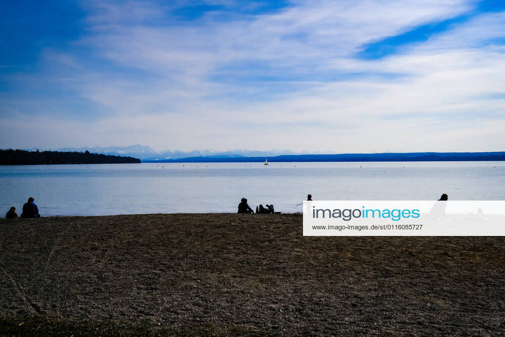 Spring weather at the Ammersee 25 03 2021 Excursionist in spring weather at the shore of the Ammersee near Stegen Inning at the Ammersee Upper Bavaria with view towards the Alps Inning Bavaria Germany