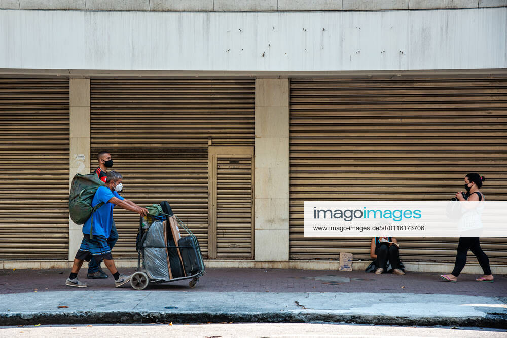 Emergency Pause in Rio RIO DE JANEIRO, BRAZIL, MAR 26: EMERGENCY PAUSE IN RIO - Homeless people wakk in front of closed store in the high-end neighborhood of Ipanema since the mayor declared a 10-day emergency pause in activities in an attempt to reduce COVID-19 cases in the city on March 26, 2021. ( Photo by Chico Ferreira Penta Press ) Rio de Janeiro Brazil 6427_235959
