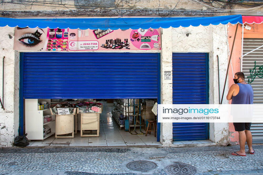 Emergency Pause in Rio RIO DE JANEIRO, BRAZIL, MAR 26: EMERGENCY PAUSE IN RIO - stores with semi-closed doors to circumvent the restriction of opening at a downtown popular shopping street since the mayor declared a 10-day emergency pause in activities in an attempt to reduce COVID-19 cases in the city on March 26, 2021. ( Photo by Chico Ferreira Penta Press ) Rio de Janeiro Brazil 6427_235964