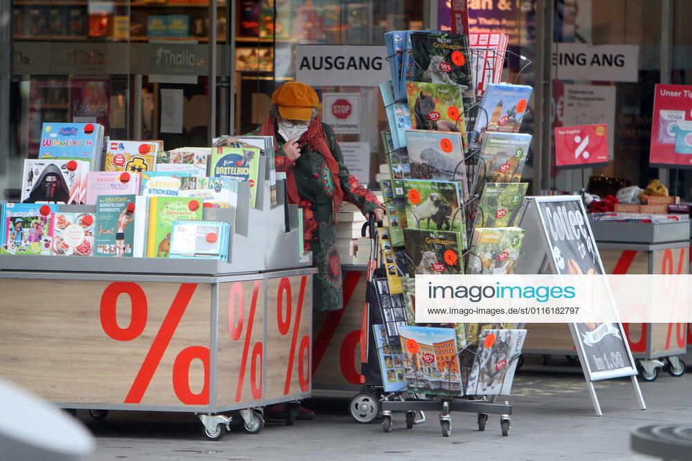 A customer browses in a rack of an open bookstore in downtown Mannheim, Baden Württemberg, Germany