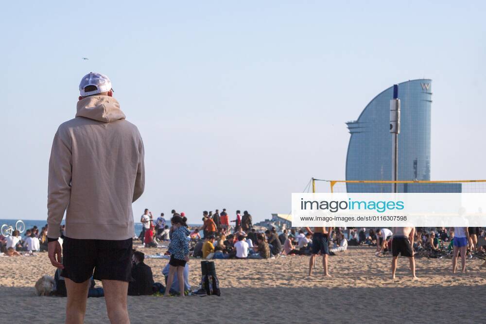 People are seen on the beach of Barceloneta.Barceloneta Beach in Barcelona is full in the 2021 beach season. In a state of alarm due to the corona virus pandemic, in Catalonia, the use of a mask and safety distances are mandatory in all public spaces to contain the spread of COVID- 19 Barcelona Spain - ZUMAd159 20210403_zia_d159_059
